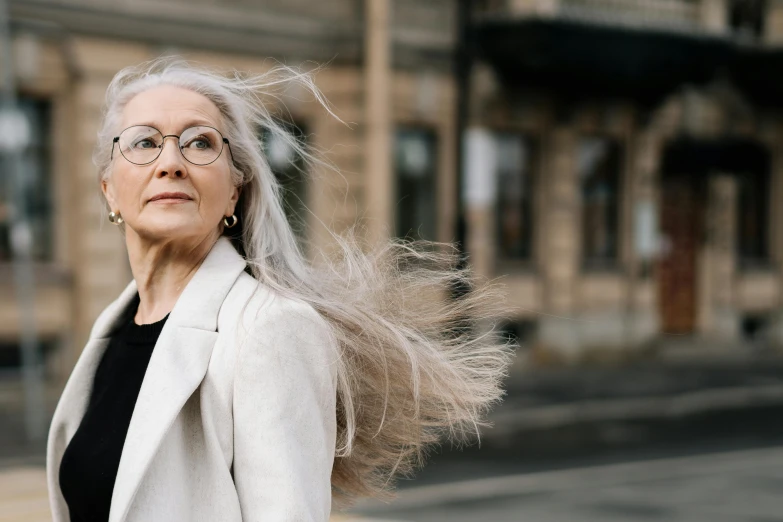 a woman in glasses walking down a street