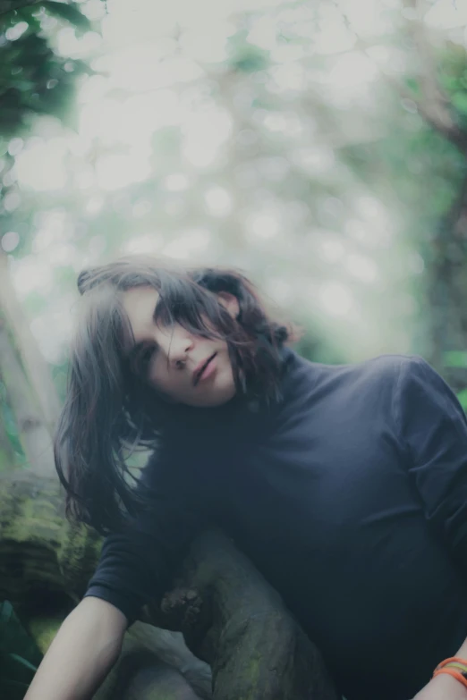 a woman laying on rocks in the forest