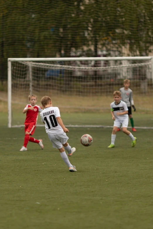 some boys playing a soccer game with the ball