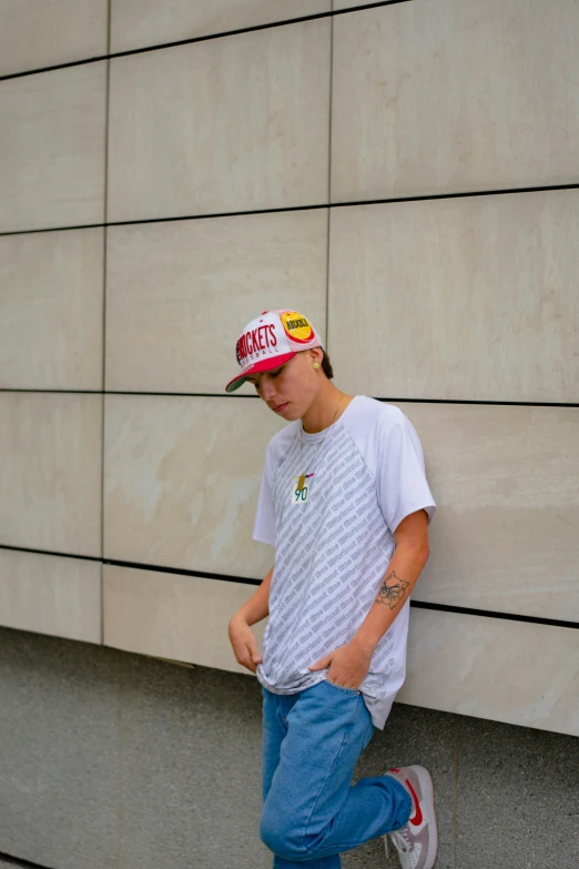 a man standing in front of a building with a hat on