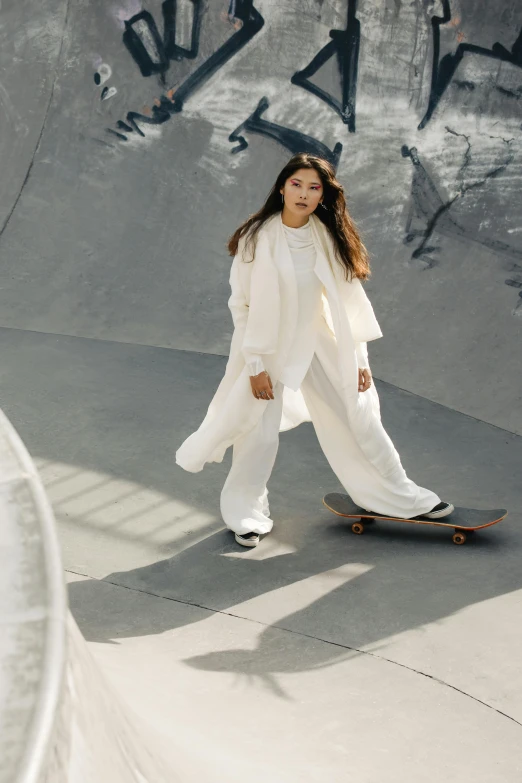 a woman is standing on her skateboard in a concrete skate park