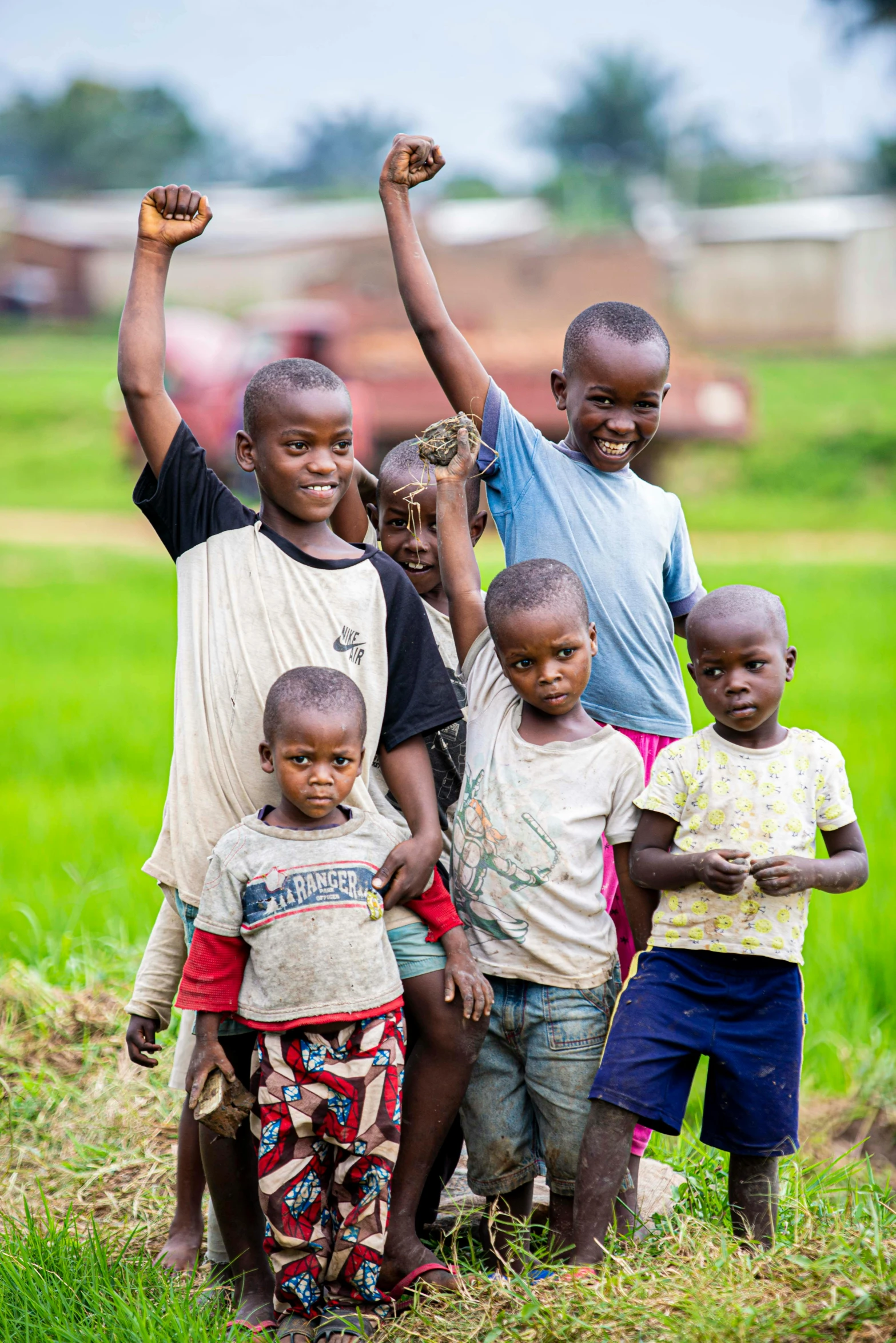 a group of children standing together holding their hands in the air