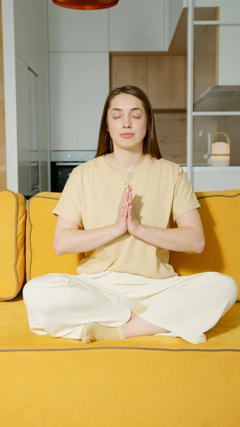 a person is doing yoga in front of an orange couch