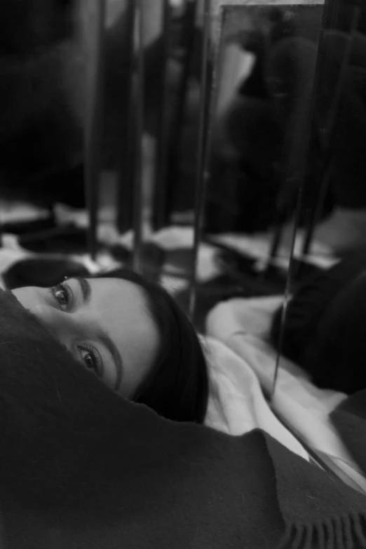 a black and white po of a woman laying on a bed