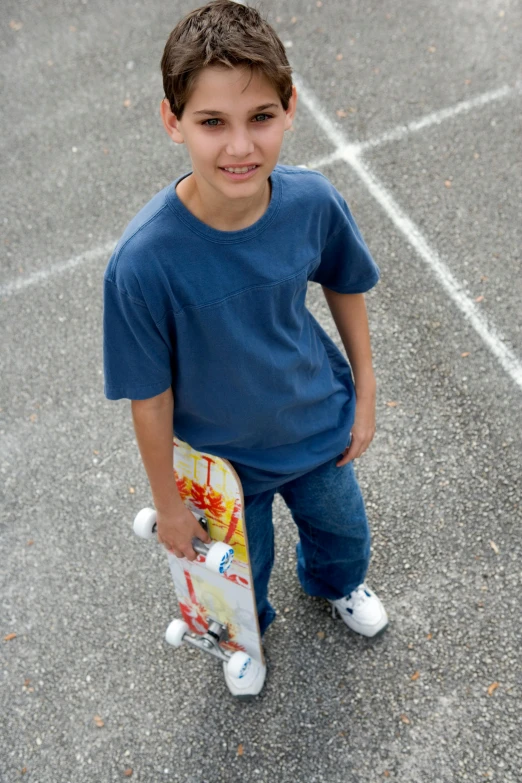 a  smiles while holding a skate board