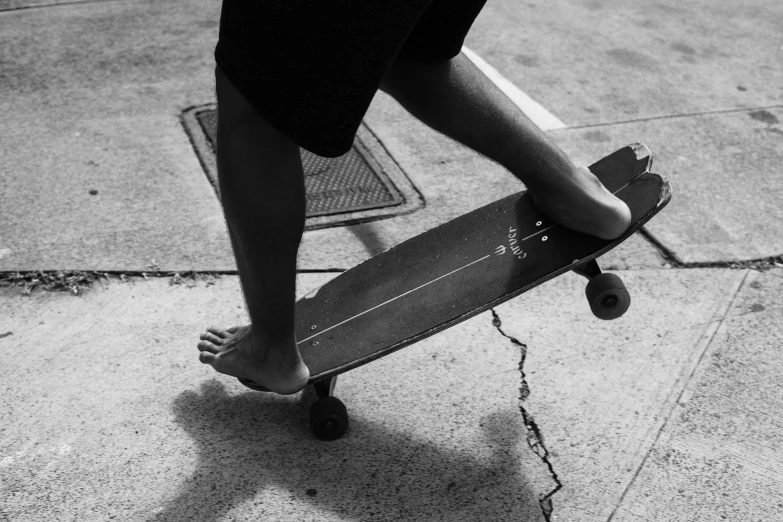 a person riding on a skateboard down a sidewalk