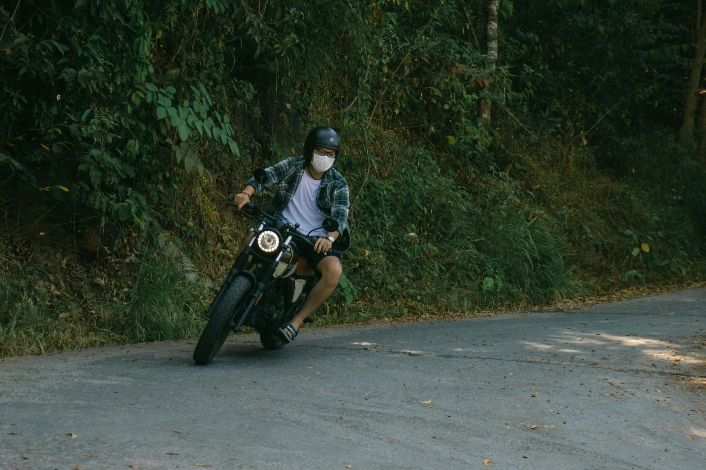 a man riding on the back of a motorcycle down a street