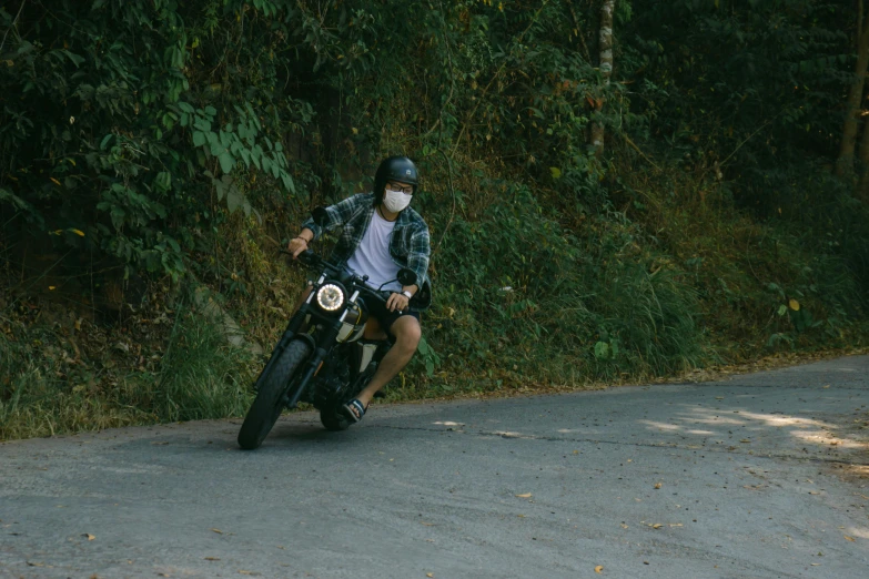 a man riding on the back of a motorcycle down a street