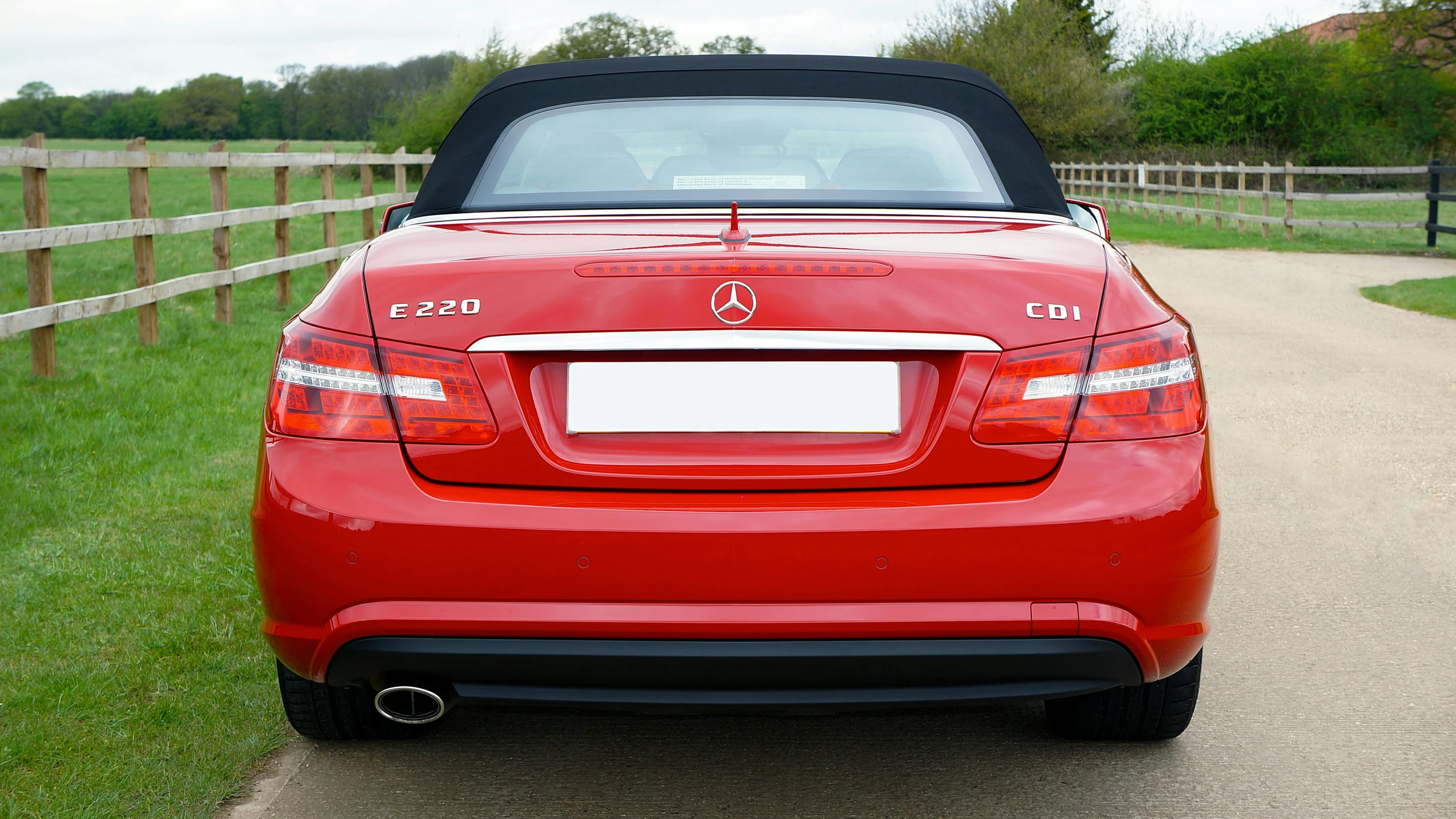 an convertible sports car is parked in the driveway