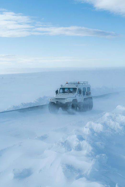 a truck is driving in the snow on a bright day