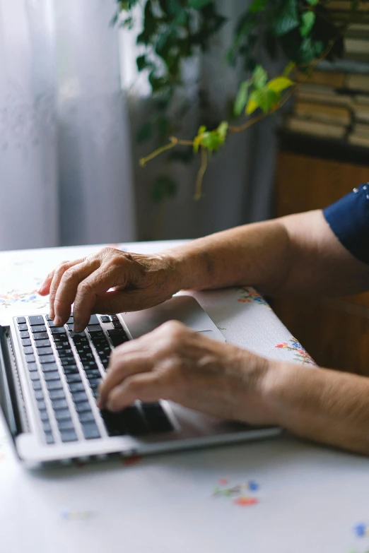 a person typing on a laptop on a table