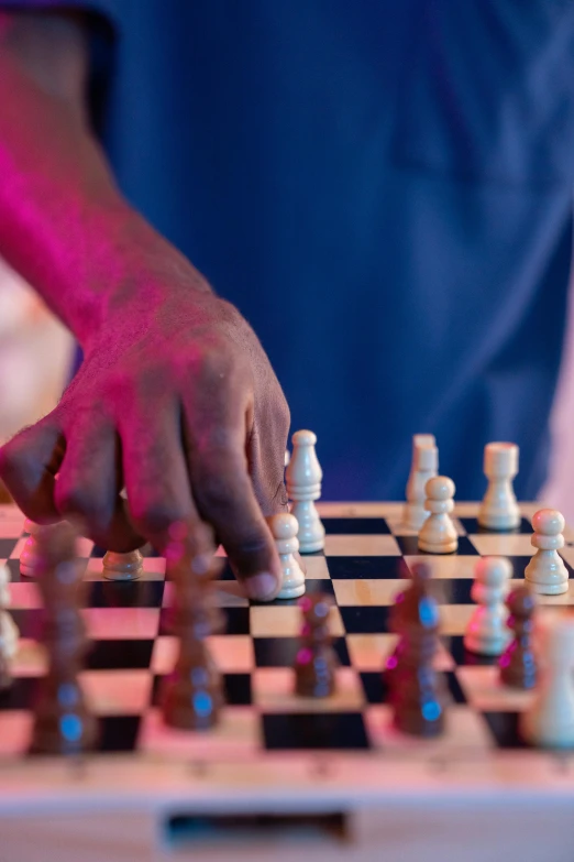 a person holding a piece of chess as it moves on the board