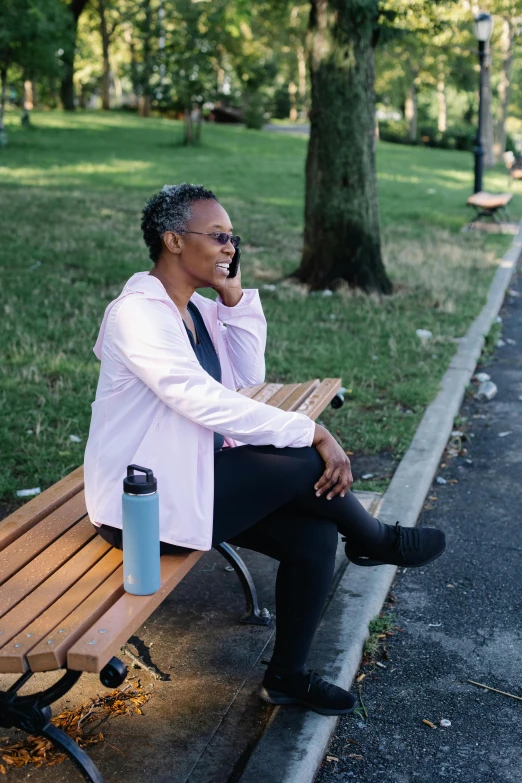 a woman on the phone sitting at a park bench