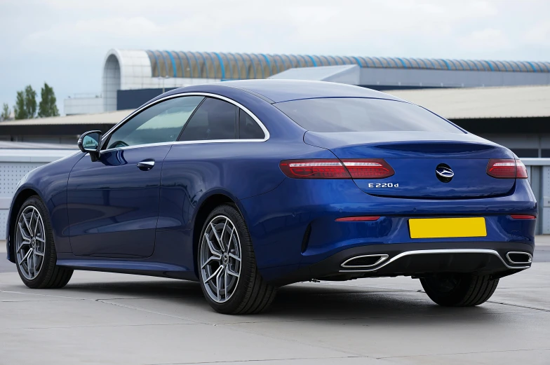 a very sleek blue mercedes s - class parked in a lot