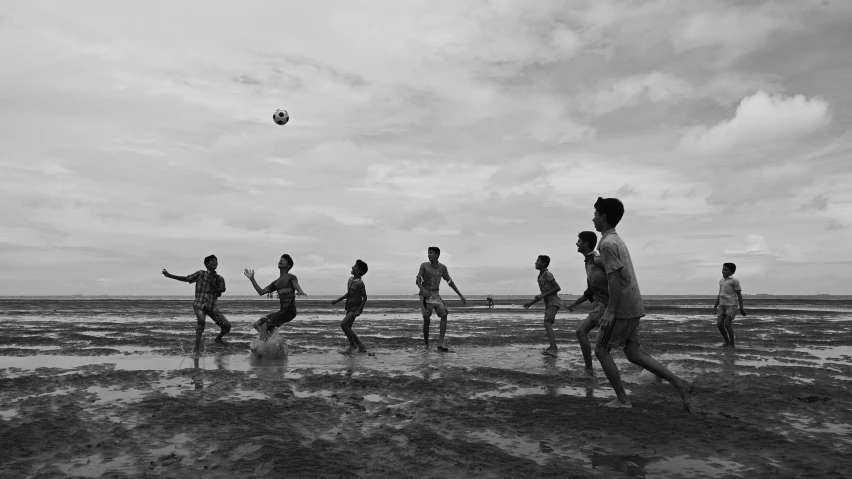 a group of people on a beach with a soccer ball