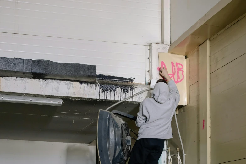 a man moving a sign from the back of a garage