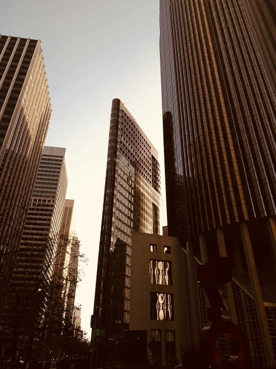 two tall buildings next to each other against a sunlit sky