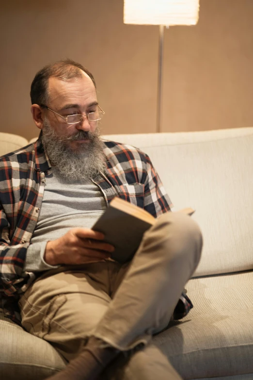 a man sitting on a couch looking at his book