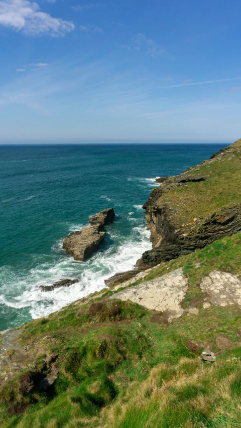 there is an ocean and green land near the beach