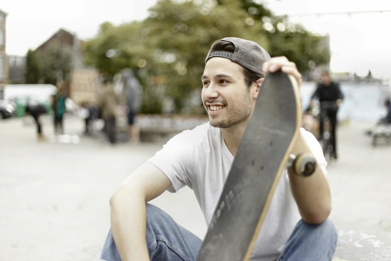 a man with a skateboard sitting on the street
