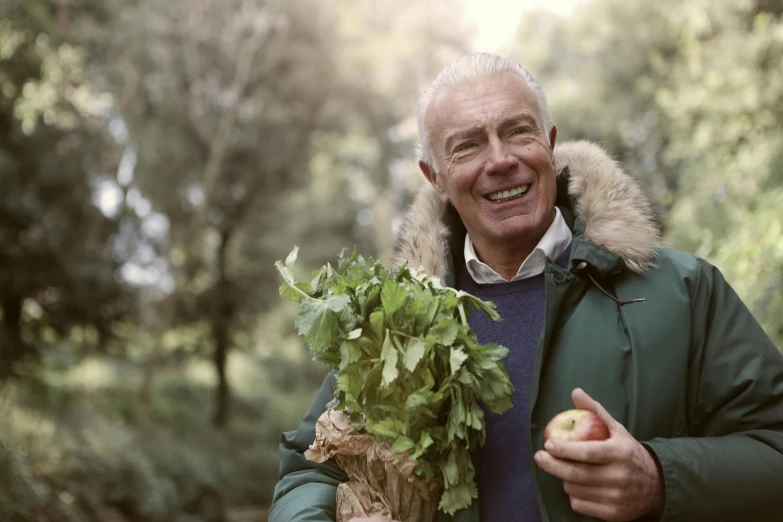 a man holding a basket filled with greens