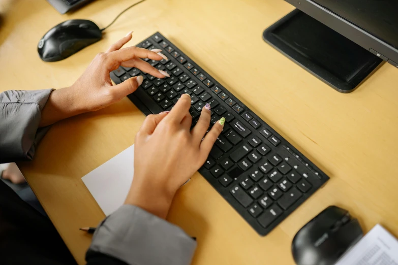 a person is typing on a black computer keyboard