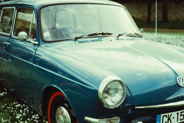 old vw type car sits parked in a grassy field