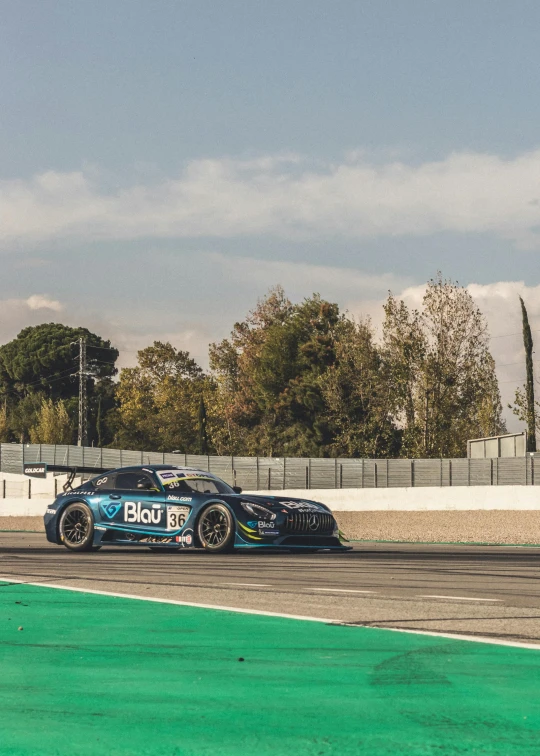 a bmw on the track in front of the fence