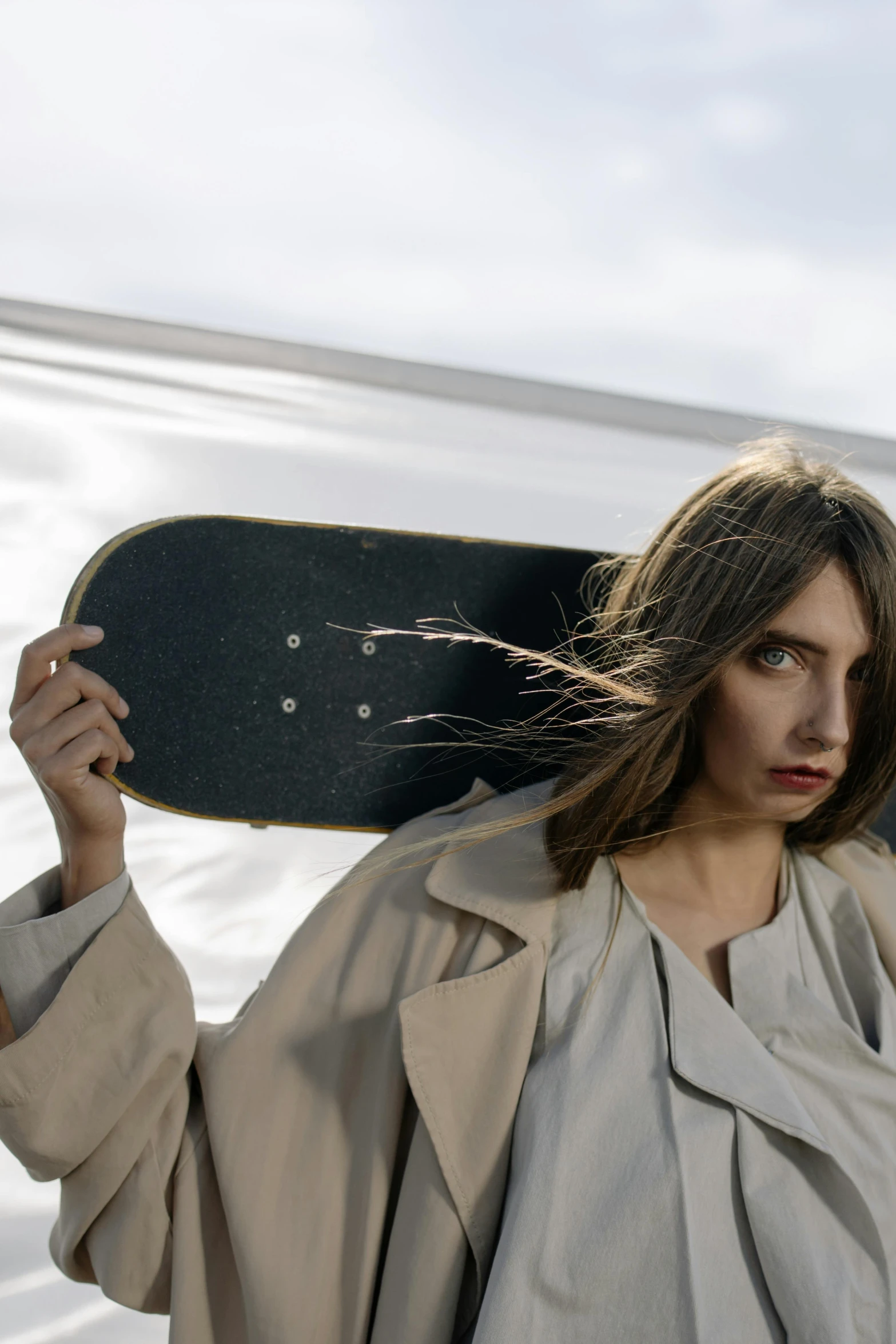 a woman with brown hair holding up a skateboard