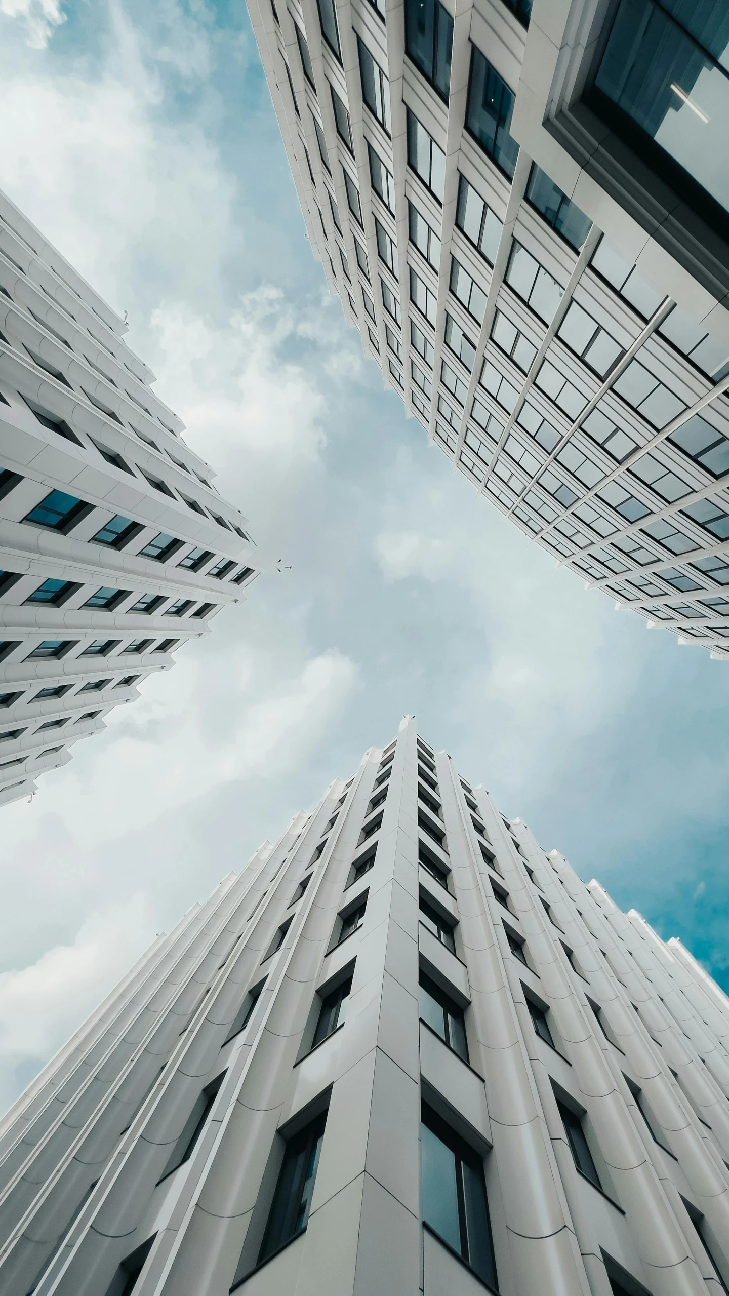 three tall buildings looking up at the sky