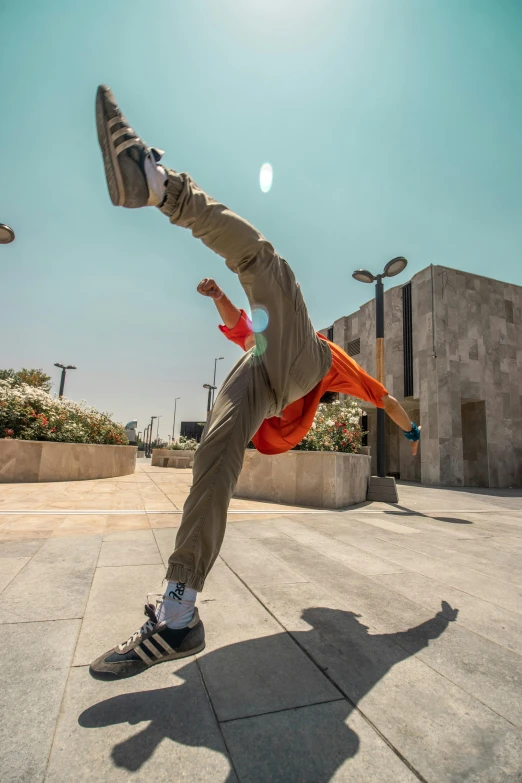 skateboarder balancing on concrete area with orange scarf