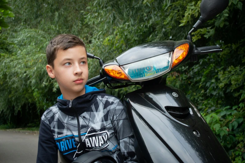 a young man is sitting on a motorcycle