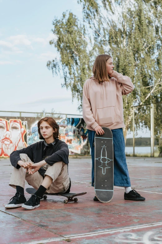 two women holding skateboards and posing for the camera