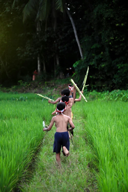 two young s wearing headgears while playing in a grassy field