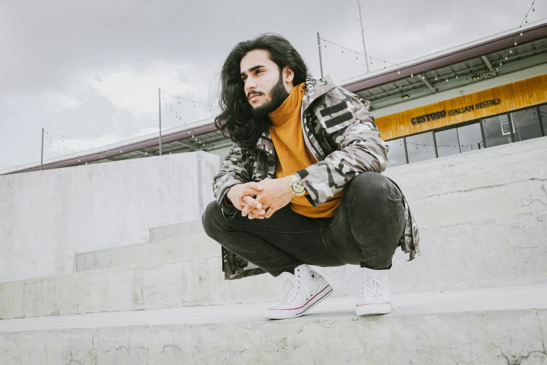 a man in plaid jacket kneeling down on concrete