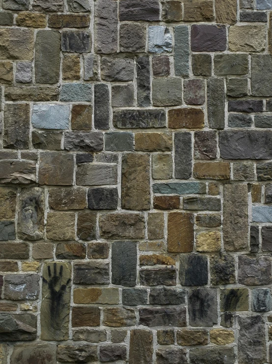 a brown brick wall with gray and tan stone