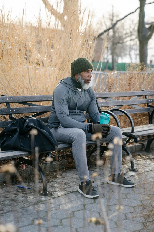 a man in cold weather clothing sitting on a bench