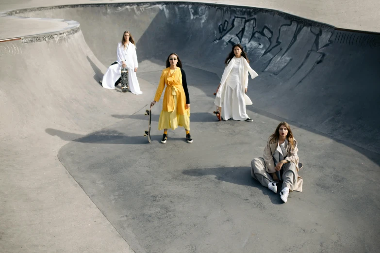 four women with skateboards standing next to the ramp