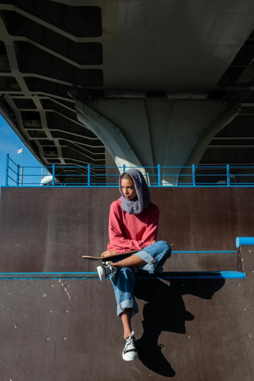 a woman sitting on the edge of a ramp