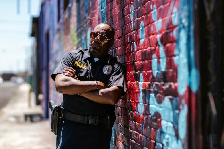 a man is standing next to a colorful wall