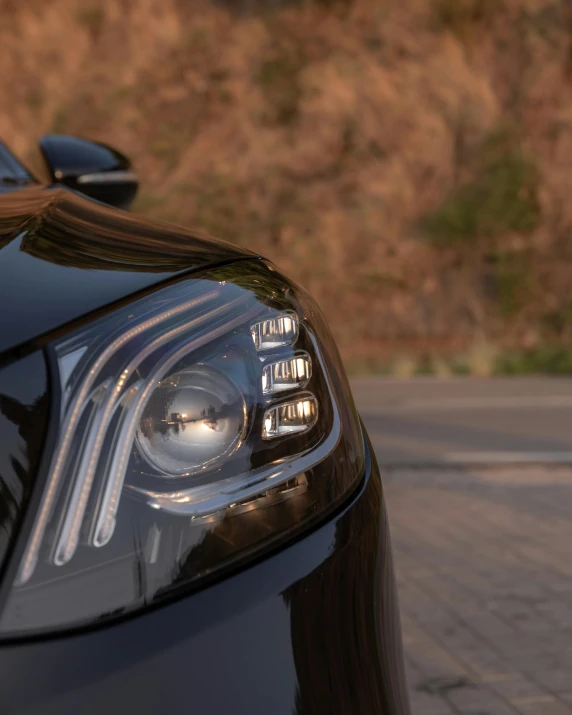 a car parked on the side of a street next to a hillside