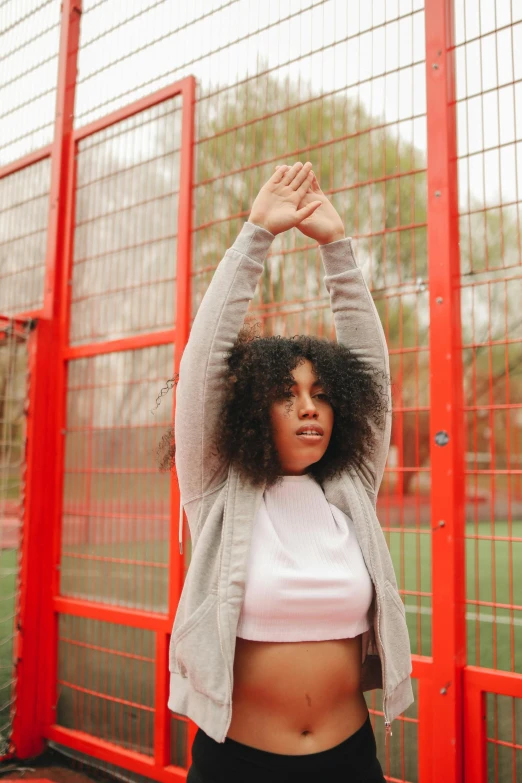 a woman with her hands up is doing yoga