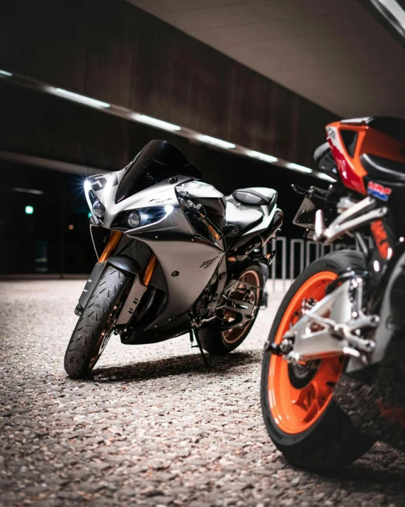 an orange and white motor cycle parked next to each other on the road