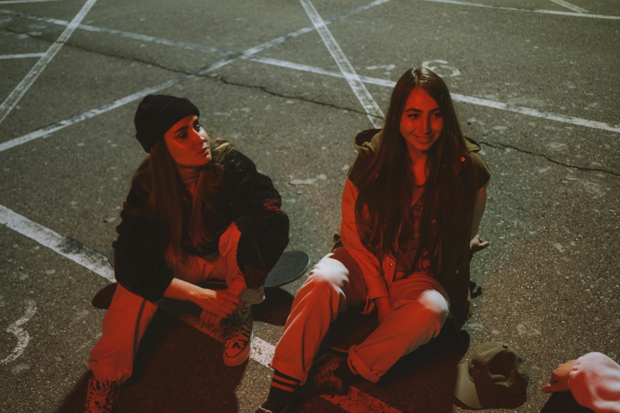 two young people sitting next to each other on a skateboard