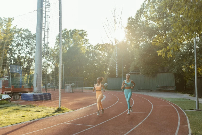 two women running on a track near the grass