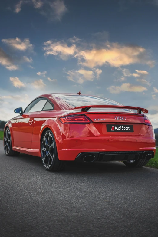 a bright red sports car driving down a country road