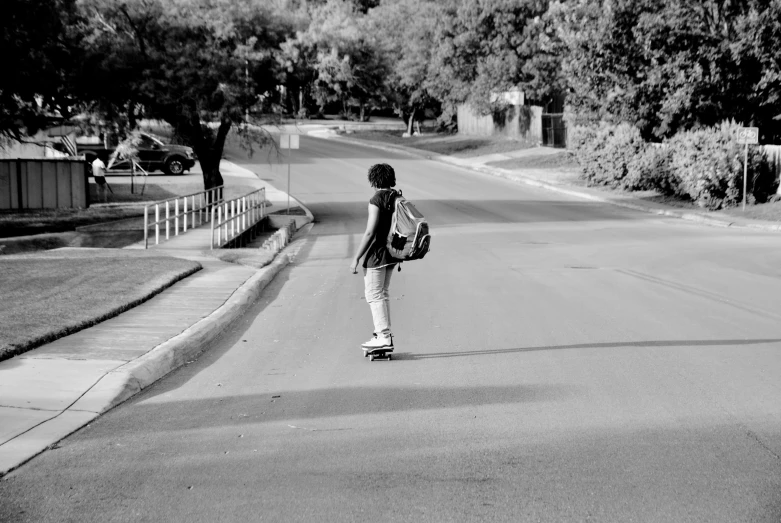 there is a boy that is skateboarding down the street