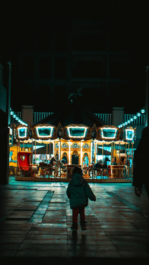 a child walking on the sidewalk at night