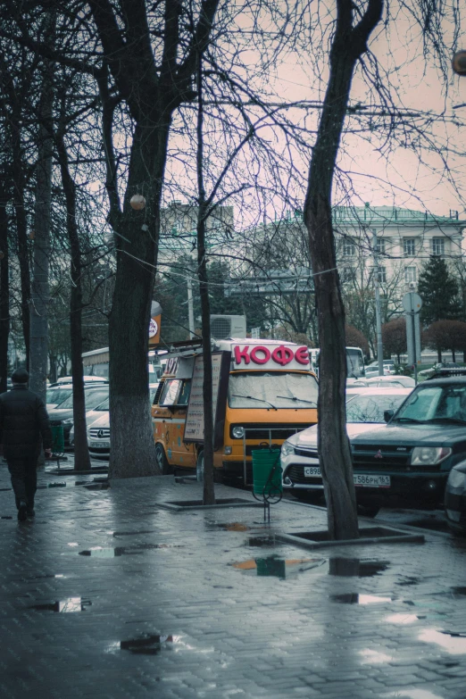 the people are walking in the rain on the sidewalk