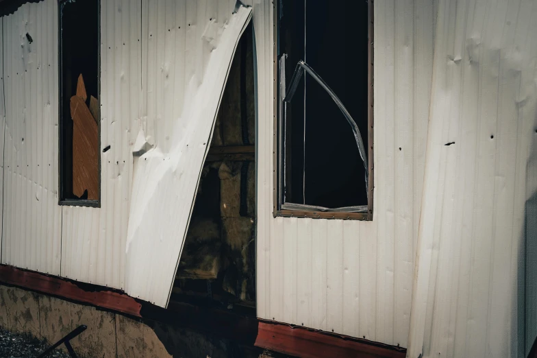 a broken up and damaged building with an old window